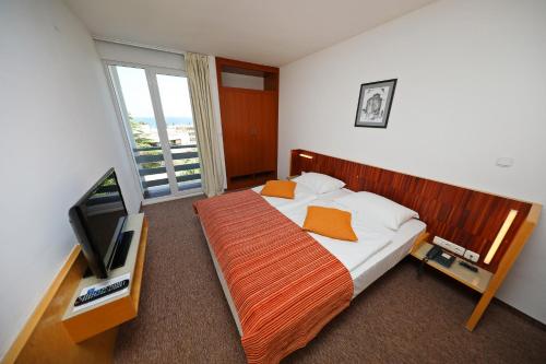 扎达尔Hotel Donat - All Inclusive的一间卧室配有一张床和一台平面电视