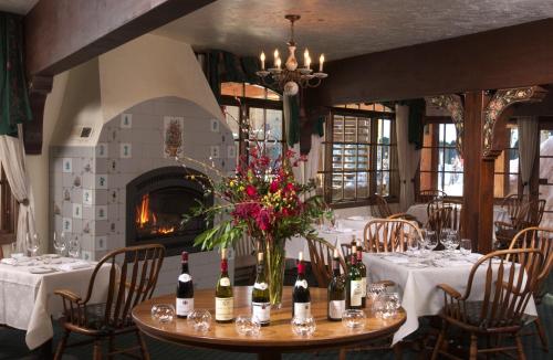 提顿村阿尔彭霍夫酒店的用餐室配有带葡萄酒瓶的桌子