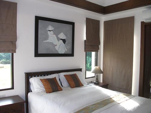 班奥南矛利拉瓦地花园度假村的一间卧室配有一张带白色床单和窗户的床。