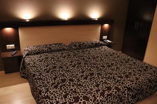 巴罗斯自由镇阿科斯塔音乐之城酒店的一间卧室配有一张带黑白色棉被的床