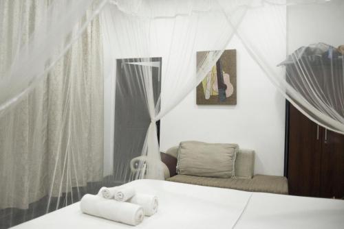 乌纳瓦图纳Butterfly Jewel的一间卧室配有一张床、一把椅子和毛巾