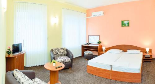 瓦尔纳Family Hotel Varna的酒店客房,配有一张床和两把椅子