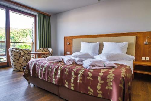 柳托梅尔HOTEL Bioterme Mala Nedelja的一间卧室配有一张大床和毛巾