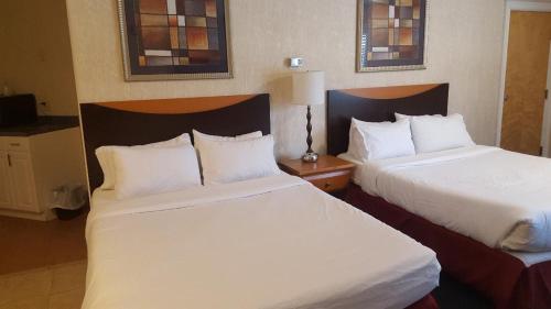 北斯托宁顿锡达帕克酒店的配有白色床单的酒店客房内的两张床