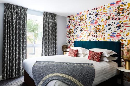 伦敦普特尼小屋酒店的一间卧室设有一张大床和色彩缤纷的墙壁