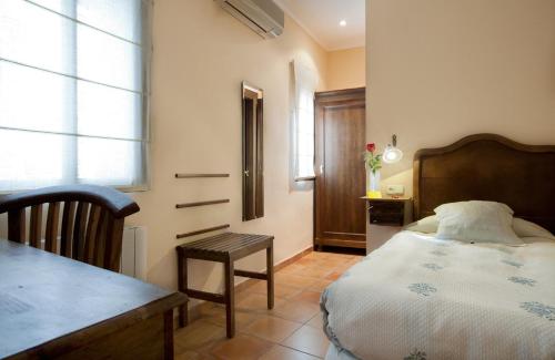 卡塞雷斯卡塞雷斯唐卡洛斯酒店的卧室配有床、桌子和窗户。