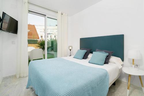 瓦伦西亚Flatsforyou Ruzafa的一间卧室配有一张带蓝色枕头的大床