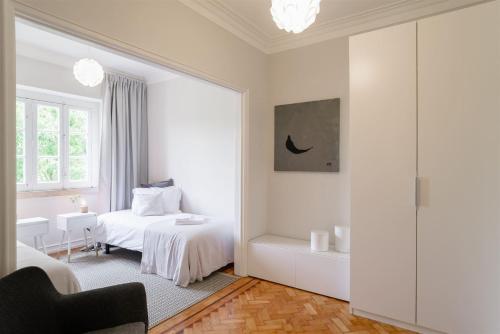 里斯本Pedrouços 37的一间白色卧室,配有床和一间浴室