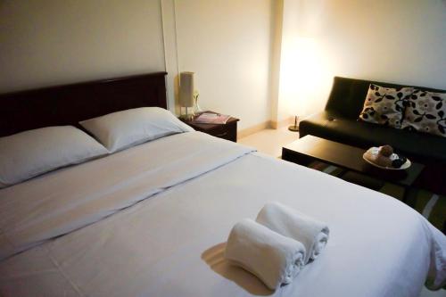 班达拉朗西博纳楠班公寓的卧室配有带毛巾的大型白色床