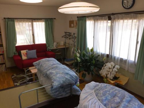 KonanGuesthouse Suisennosato的一间带两张床和一张沙发的客厅