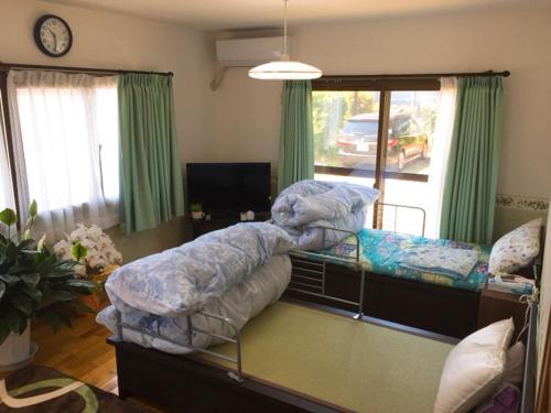 KonanGuesthouse Suisennosato的一间带两张双层床和电视的卧室