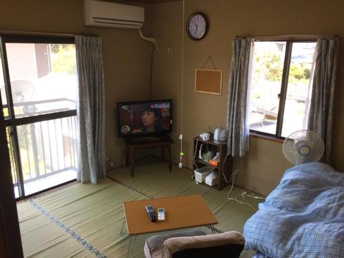 KonanGuesthouse Suisennosato的客厅配有电视和桌子