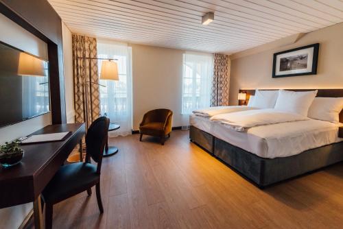 Tafers塔瓦纳酒店的配有一张床和一张书桌的酒店客房