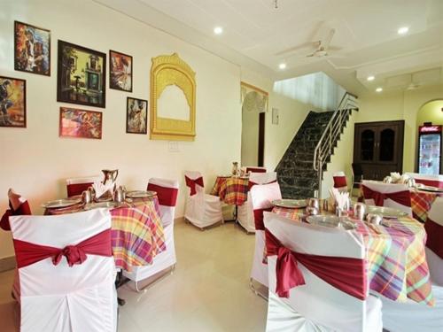 阿格拉Taj Haveli Agra - 5 Minute Walking Distance from Taj Mahal Agra的餐厅设有白色桌子和红色及白色的椅子