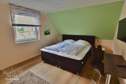 格赫伦-莱宾Villa Fleesenstrand的一间卧室配有一张床、一张桌子和一个窗户。