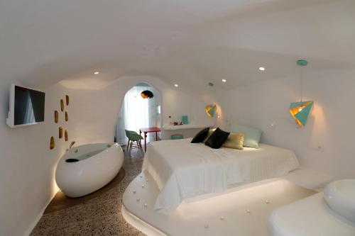 斯泰里达Naxos Cave Suites的白色卧室配有白色的床和浴缸