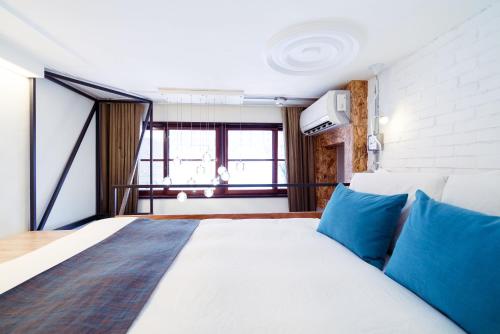 高雄同.居青年旅馆的一间卧室配有一张带蓝色枕头的大床