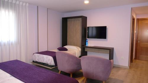 纳瓦莱诺El Nido de Pinares的酒店客房设有两张床和电视。