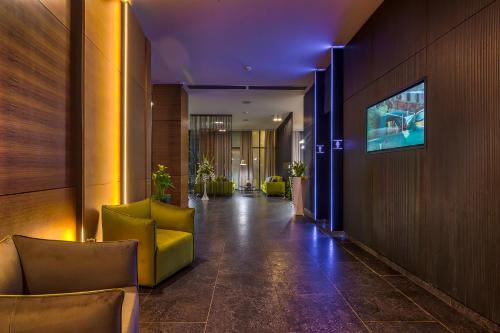 马马亚Nyota Hotel & Conference Center的大楼内带椅子和电视的走廊