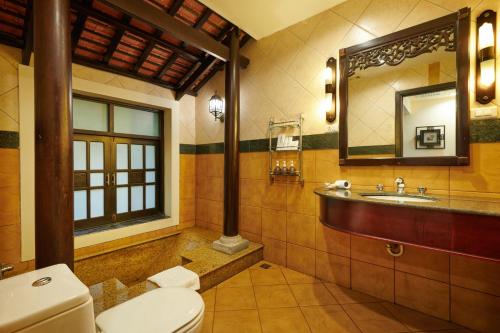 下龙湾Tuan Chau Resort Ha Long的一间带卫生间、水槽和镜子的浴室
