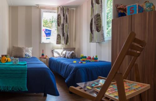 拉特斯Camping Officiel Siblu Le Lac des Rêves的儿童卧室设有两张床和一扇窗户