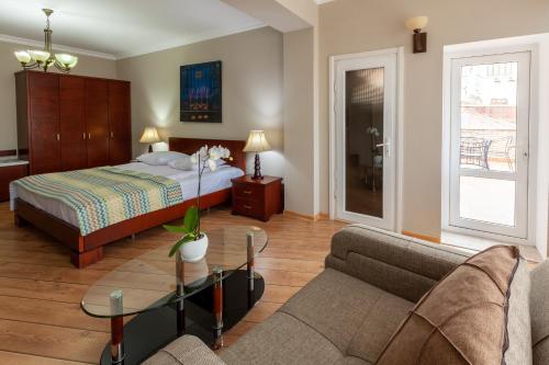 第比利斯阁楼酒店的一间卧室配有一张床、一张沙发和一张桌子