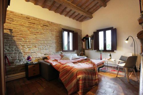 Serra deʼ Contiquindici alberi的一间卧室设有一张床和砖墙
