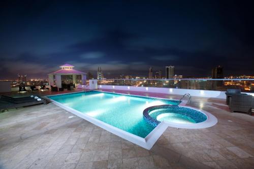麦纳麦Al Olaya Suites Hotel的一座建筑物屋顶上的游泳池