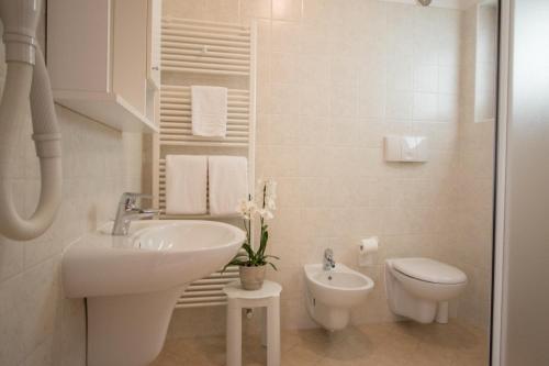 加尔达湖滨Agritur Comai的白色的浴室设有水槽和卫生间。