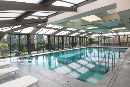 圣马洛格兰德酒店的一个带玻璃窗的大型游泳池和一个大型游泳池