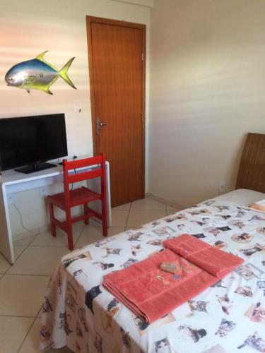 伊塔佩鲁纳Casa da Jussara的一间卧室配有一张床和一张桌子,墙上挂着一条鱼