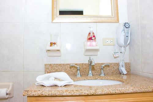 金斯敦亚历山大酒店的一间带镜子和电话的盥洗盆的浴室
