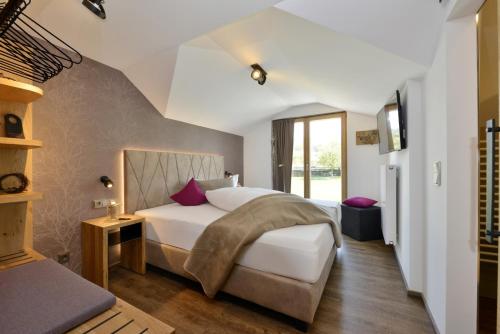 弗劳埃瑙瓦尔德克里斯托尔膳食公寓的一间卧室配有一张带白色床单和紫色枕头的床