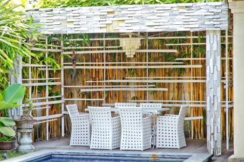 沙努尔竹月别墅的一个带桌椅的庭院和围栏