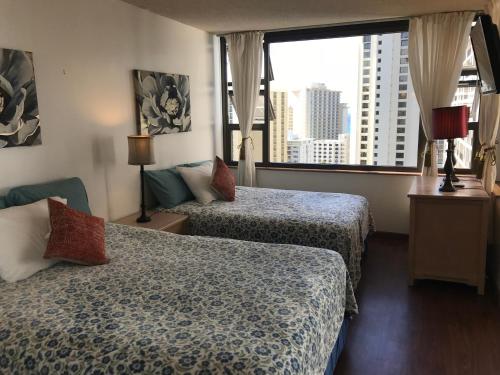 檀香山Waikiki Banyan的酒店客房设有两张床和大窗户。