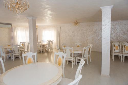 博托沙尼Pensiunea Dallas的一间配备有白色桌椅和吊灯的餐厅