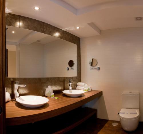 Guísamo欧斯奥利弗斯酒店的一间带两个盥洗盆和大镜子的浴室