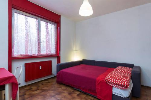 诺瓦拉[Ospedale] Casa DeMedicis的一间卧室配有一张带红色毯子的床和两个窗户。