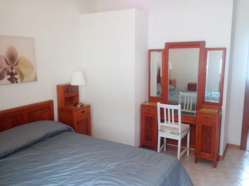 格拉多Appartamento Perco Riva Slataper的一间卧室配有一张床、梳妆台和镜子