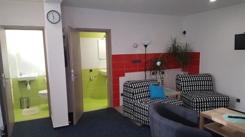 NěmčičkyUbytování Němčičky的一间带两把椅子的客厅和一间浴室