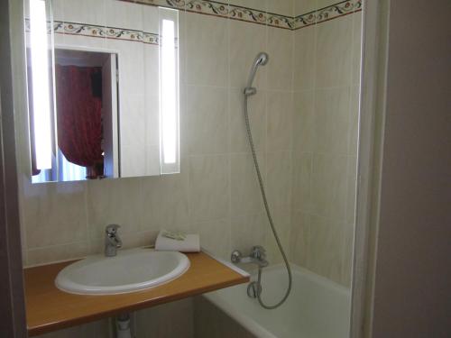 巴黎尼斯酒店的浴室配有水槽、淋浴和浴缸。