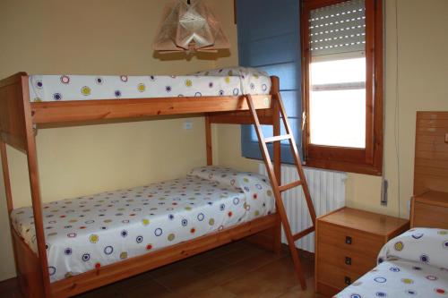 AlcoletgeCA L'AMPURDANES的一间卧室设有两张双层床和一扇窗户。
