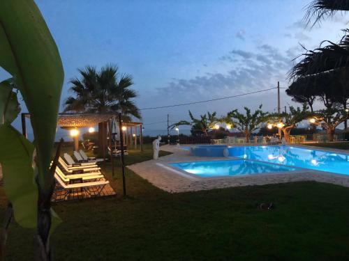 瓦尔索洛米翁Glyfa Beach Hotel的毗邻度假酒店的带躺椅的游泳池