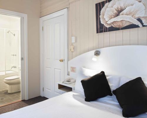 肯图巴蓝山文物汽车旅馆 的一间卧室配有一张床,浴室设有卫生间