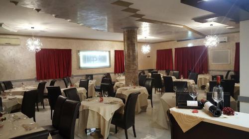 法莱尔纳天堂酒店的一间配备有桌椅和红色窗帘的用餐室