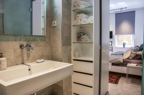 萨格勒布Downtown Beauty Apartment的一间带水槽的浴室和一张位于客房内的床