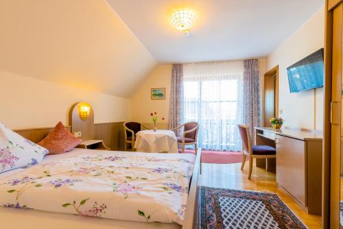格恩斯巴赫Gästehaus Sonne的酒店客房带一张床、一张桌子和椅子