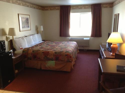 盐湖城Royal Inn Airport Salt Lake City的酒店客房设有床和窗户。