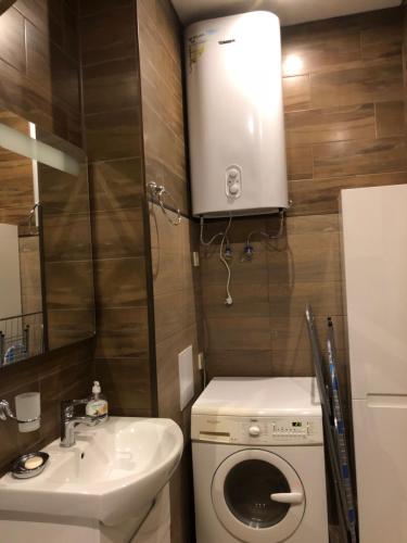 敖德萨Zhemchuzhnie apartments on Marselskaya的小型浴室设有洗衣机和水槽。