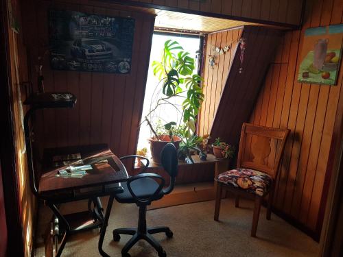 蓬塔阿雷纳斯La Casa Guesthouse的客房设有书桌、椅子和窗户。
